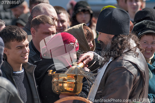 Image of Priest blessing people with holy water. Tyumen