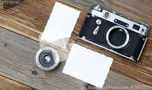 Image of retro photo mock up, vintage camera and lens on old wooden backg