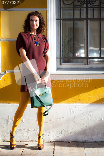 Image of pretty middle-aged woman with a green handbag