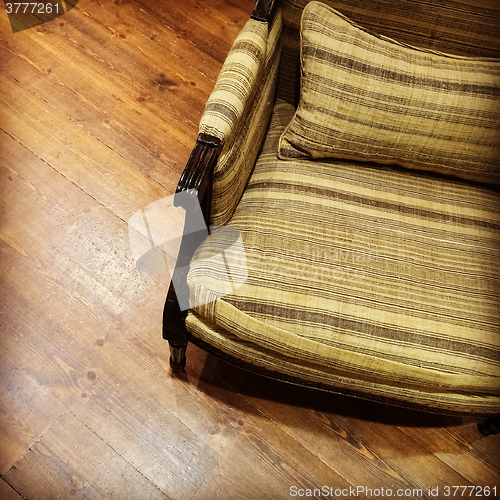 Image of Vintage green armchair on wooden floor