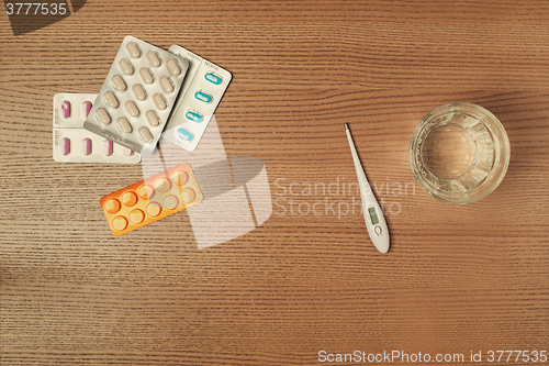 Image of Thermometer, pills and glass of water