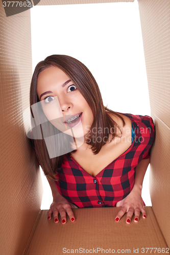 Image of Girl opening a carton box and looking inside