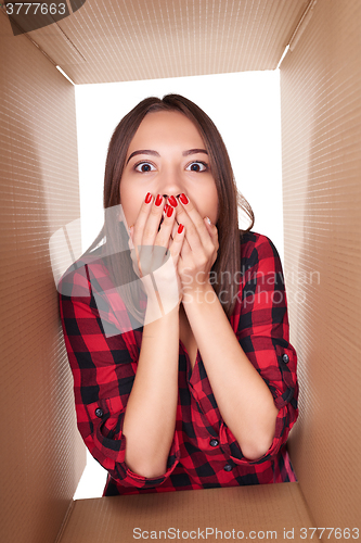 Image of Girl opening a carton box and looking inside