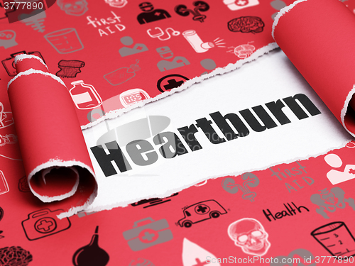 Image of Medicine concept: black text Heartburn under the piece of  torn paper