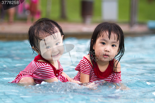 Image of Two Little Sisters Playing in Water