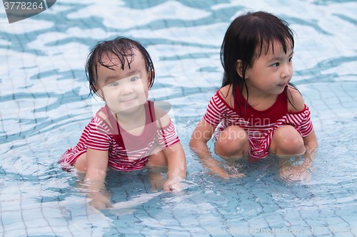 Image of Two Little Sisters Playing in Water