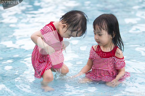 Image of Two Little Sisters Playing in Water