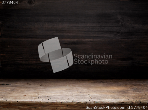 Image of wooden table and dark wooden wall