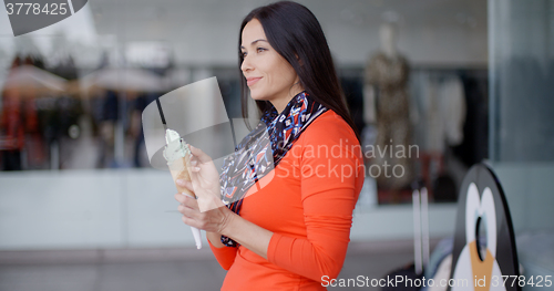 Image of Attractive young woman eating an ice cream cone