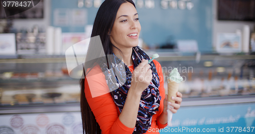 Image of Attractive stylish young woman in a delicatessen