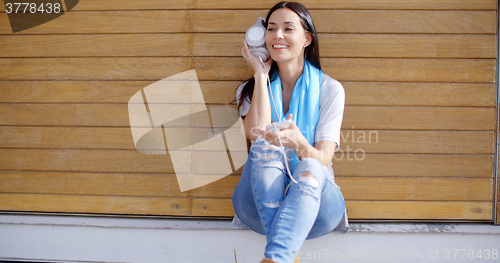 Image of Happy relaxed young woman listening to music