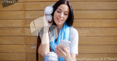 Image of Young woman listening to music on her mobile