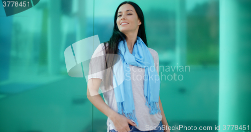 Image of Happy woman looking sideways in front of glass