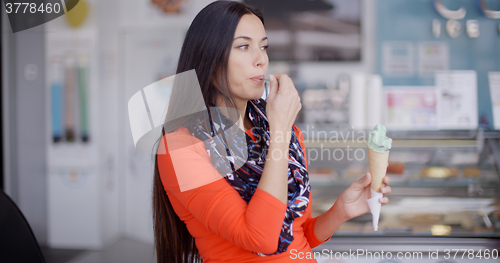 Image of Smiling young woman savoring an ice cream cone