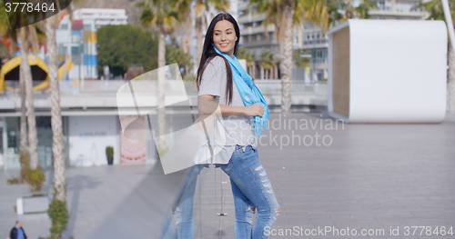 Image of Smiling woman looking back over railing