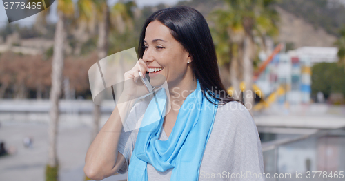 Image of Enthusiastic female using phone outdoors