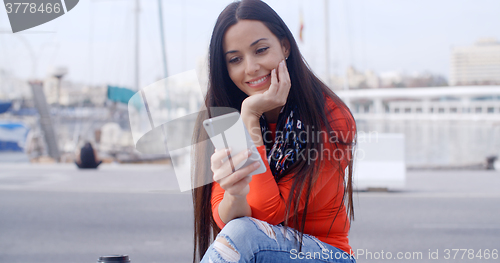 Image of Attractive woman reading a text message