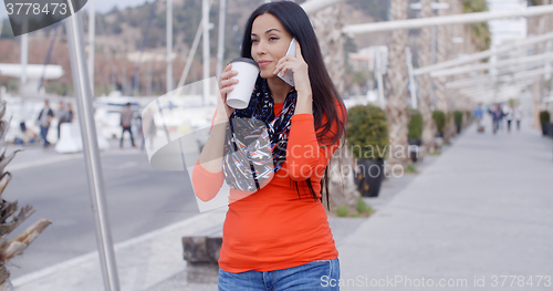 Image of Pretty chic young woman chatting on a mobile