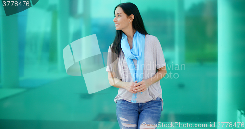 Image of Happy woman looking sideways in front of glass