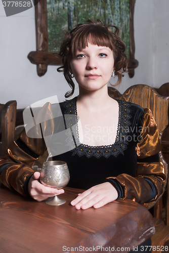 Image of Pretty woman an armchair and with wine glass