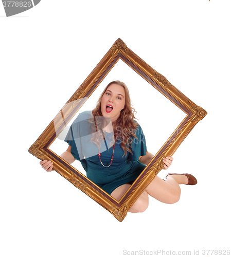 Image of Woman sitting on floor with picture frame.