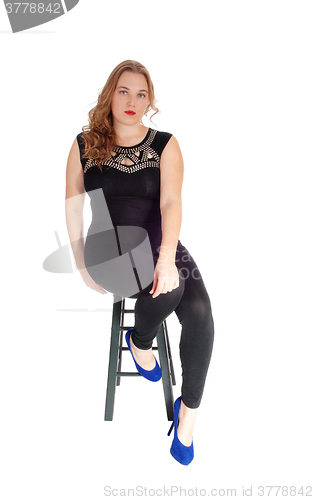 Image of Woman sitting on chair in tights.