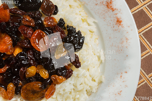 Image of Vegetarian sweet rice with dried apricots and raisins close-up on the table. 