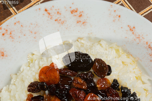 Image of Vegetarian sweet rice with dried apricots and raisins close-up on the table. 