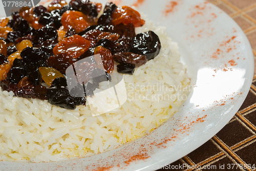 Image of Vegetarian sweet rice with dried apricots and raisins close-up on the table. 
