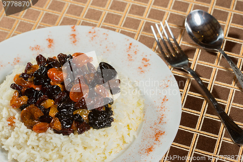 Image of Vegetarian sweet rice with dried apricots and raisins close-up on the table. 