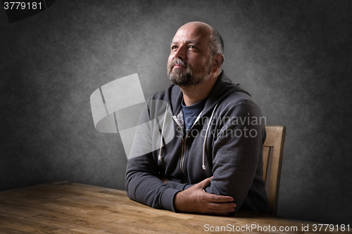 Image of Man sitting on table