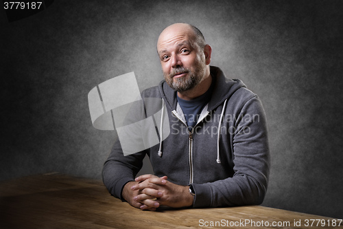 Image of Man sitting on table