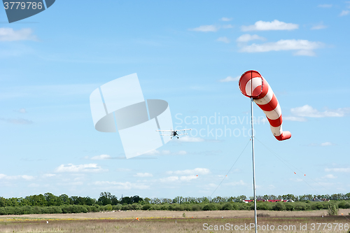 Image of Windsock against cloudy sky.
