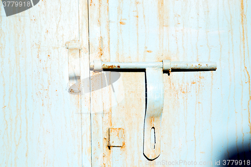 Image of blue metal rusty  in    facade home and safe padlock 