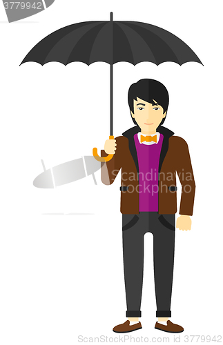 Image of Businessman standing with umbrella.