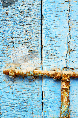 Image of      nail dirty stripped paint in the blue wood door 