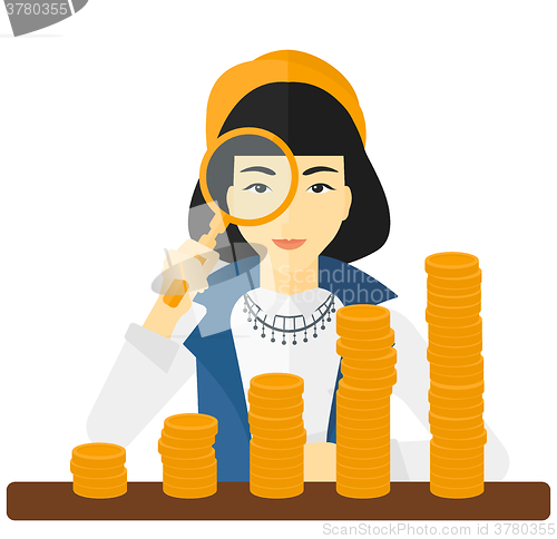 Image of Woman with magnifier and golden coins. 