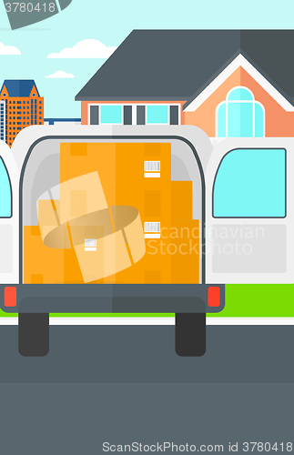 Image of Background of delivery truck with an open door and cardboard boxes in front of house.