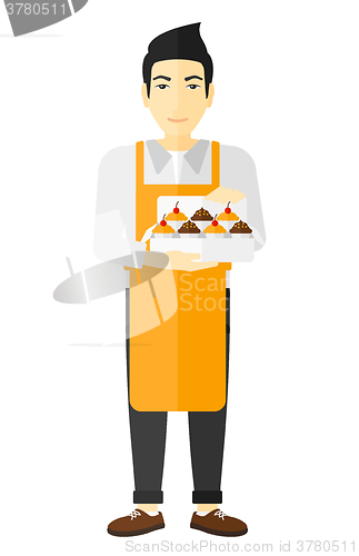Image of Baker holding box of cakes.