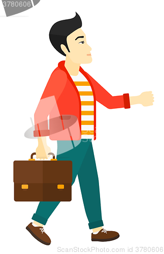 Image of Businessman walking with briefcase. 