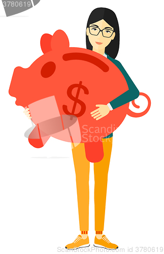 Image of Woman carrying piggy bank.