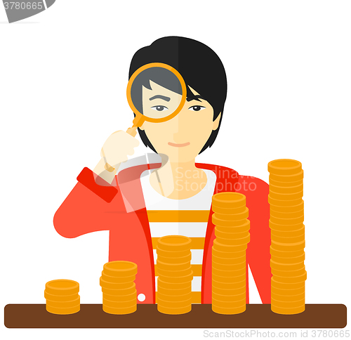 Image of Man with magnifier and golden coins. 