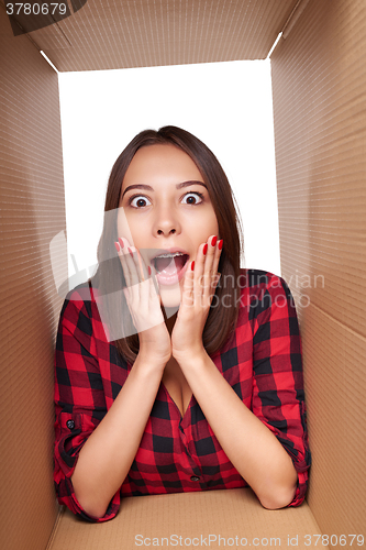 Image of Girl opening a carton box and looking inside