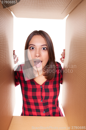 Image of Girl opening a carton box and looking inside