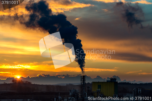 Image of Sunrise silhouette of smoking factory