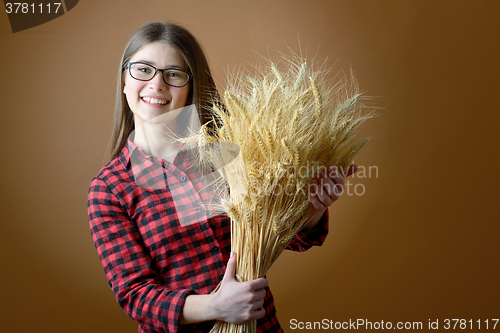 Image of girl hold in hand bunch of wheat stalks