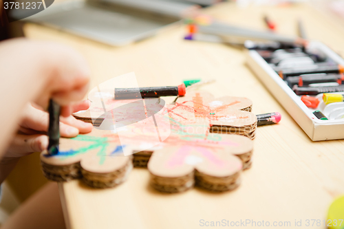 Image of Little female baby painting with colorful paints