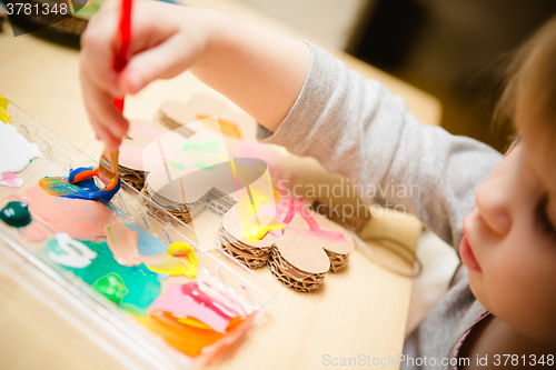 Image of Little female baby painting with colorful paints