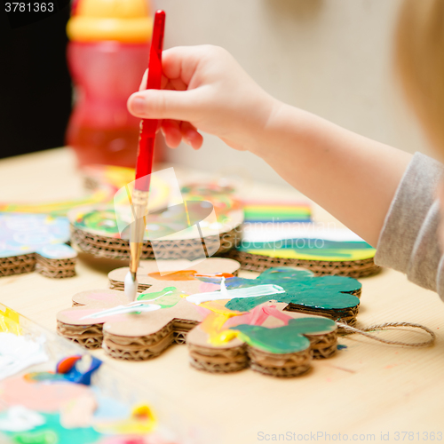 Image of Little female baby painting with colorful paints