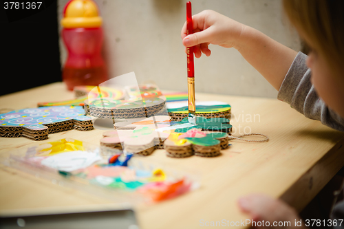 Image of Little female baby painting with colorful paints